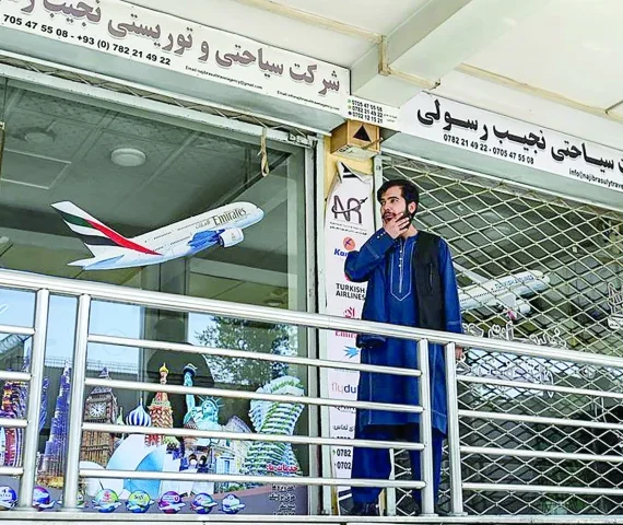 an afghan employee from a travel agency stands outside his office amid a nationwide telecom outage in kabul photo afp