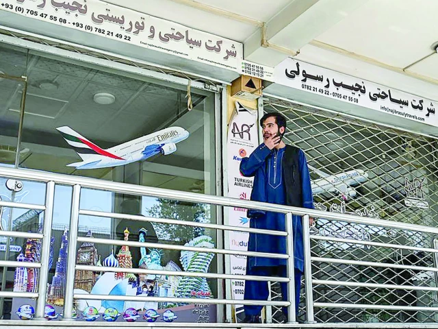 an afghan employee from a travel agency stands outside his office amid a nationwide telecom outage in kabul photo afp