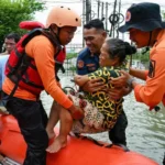 rescuers evacuate an elderly person using a rubber boat during the flood in medan north sumatra on november 28 2025 photo afp